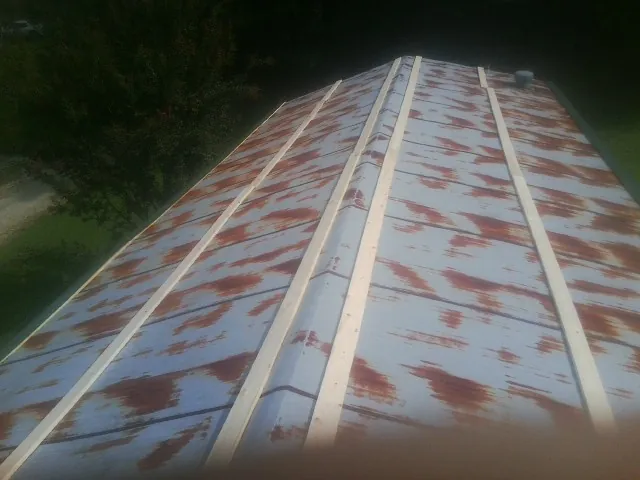 Rusted metal roof panels with new wood purlins before replacement — Storm Damage Roof Repair in Harrietta by Roofing Brothers